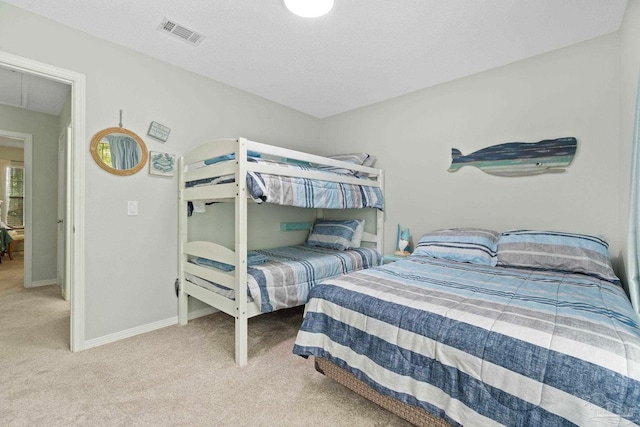 carpeted bedroom with baseboards, attic access, and visible vents
