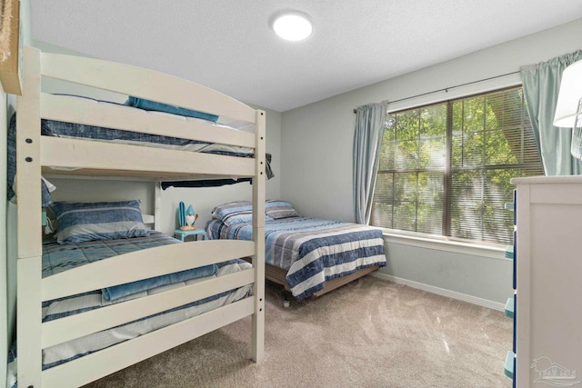 carpeted bedroom featuring baseboards and a textured ceiling