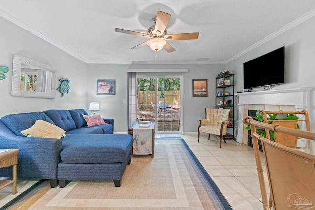 living area featuring ornamental molding, baseboards, a tiled fireplace, a ceiling fan, and light tile patterned floors