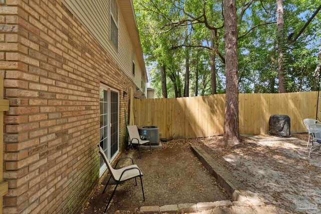 view of yard featuring central AC, fence, and a patio area