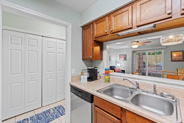 kitchen featuring brown cabinetry, a ceiling fan, dishwasher, a sink, and light tile patterned floors