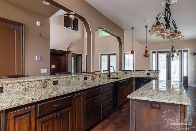 4513 River Ranch Rd, Milton, FL 32583 - kitchen featuring arched walkways, dark wood-type flooring, light stone counters, healthy amount of natural light, and lofted ceiling