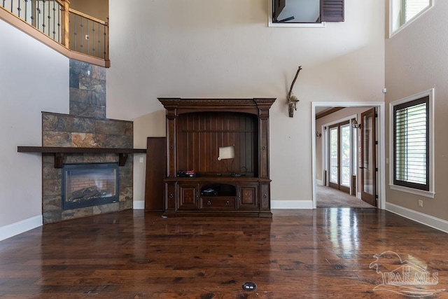 4513 River Ranch Rd, Milton, FL 32583 - unfurnished living room featuring a towering ceiling, wood finished floors, and a glass covered fireplace