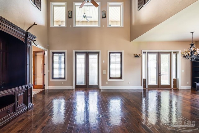 4513 River Ranch Rd, Milton, FL 32583 - unfurnished living room featuring french doors, a ceiling fan, a chandelier, a high ceiling, and wood-type flooring