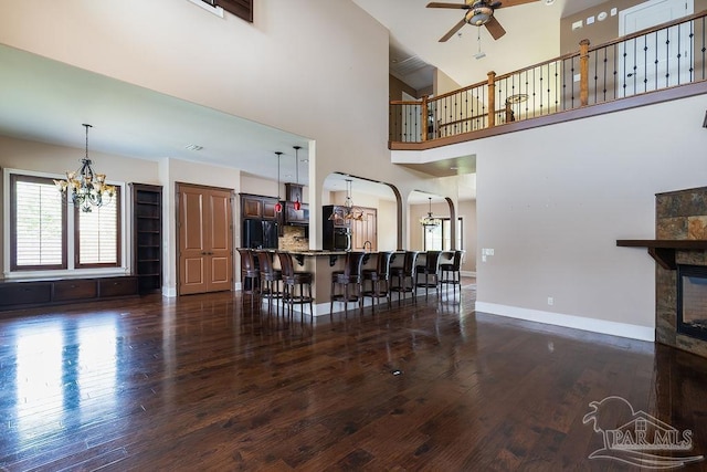 4513 River Ranch Rd, Milton, FL 32583 - living area featuring a chandelier, a ceiling fan, plenty of natural light, dark wood-style floors, and a towering ceiling