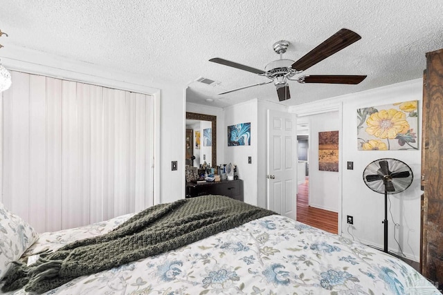 bedroom with a textured ceiling and ceiling fan