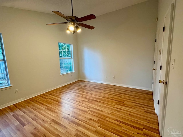 spare room with light hardwood / wood-style floors, vaulted ceiling, and ceiling fan