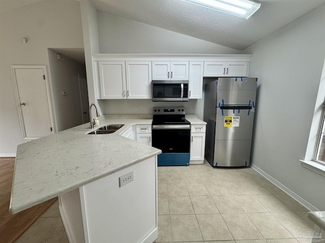 kitchen with white cabinets, sink, lofted ceiling, and stainless steel appliances