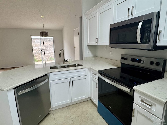 kitchen featuring lofted ceiling, white cabinets, sink, kitchen peninsula, and stainless steel appliances