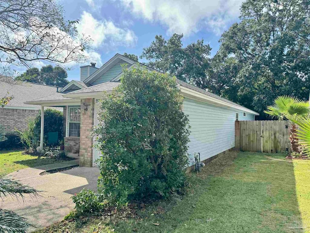 view of side of property with a yard