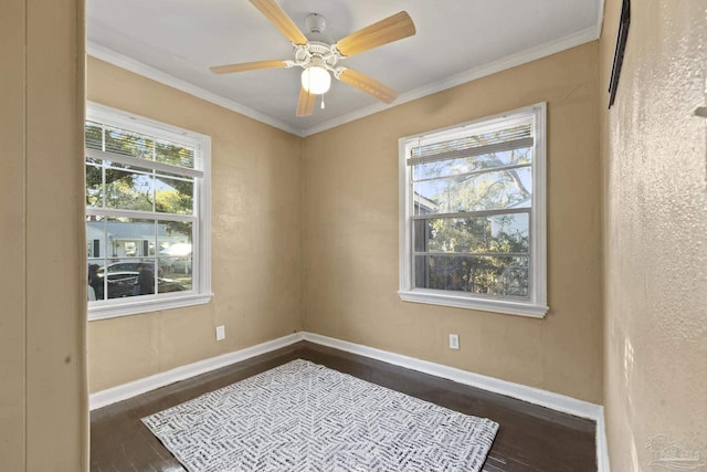 empty room with crown molding, dark wood-type flooring, and ceiling fan