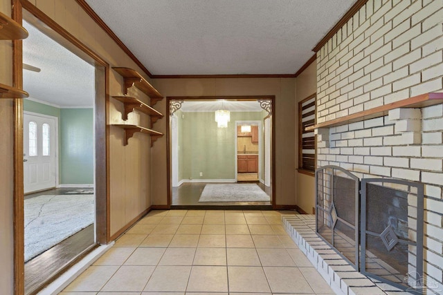 unfurnished living room featuring crown molding, a brick fireplace, light tile patterned flooring, and a textured ceiling