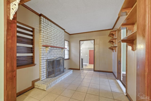 unfurnished living room with crown molding, light tile patterned flooring, a fireplace, and a textured ceiling