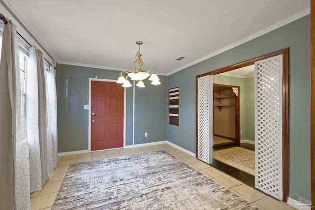 tiled spare room with an inviting chandelier and ornamental molding