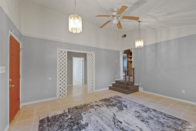 interior space featuring lofted ceiling, ceiling fan, and light tile patterned flooring