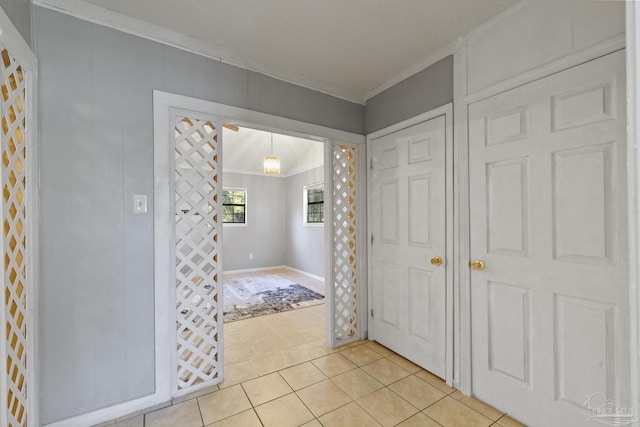 tiled entryway featuring crown molding