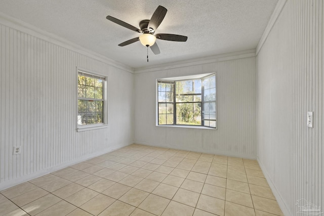 unfurnished room with ceiling fan, ornamental molding, and a textured ceiling