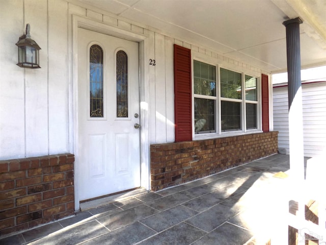 view of exterior entry featuring covered porch