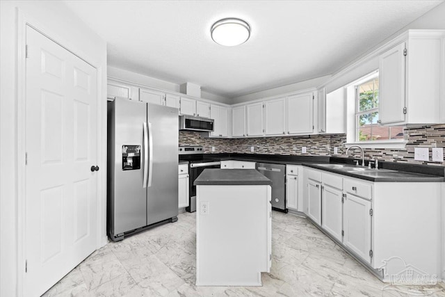 6914 Raburn Rd, Pensacola, FL 32526 - kitchen featuring marble finish floor, dark countertops, a center island, a sink, and stainless steel appliances