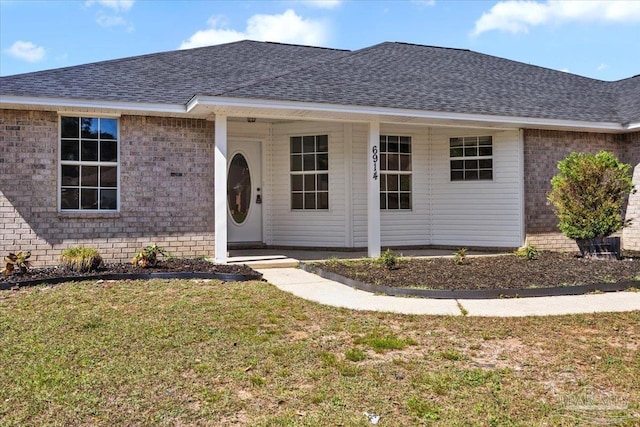 6914 Raburn Rd, Pensacola, FL 32526 - view of front of home with a porch, brick siding, a front yard, and roof with shingles