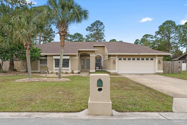 view of front of property featuring a garage, a front yard, and french doors