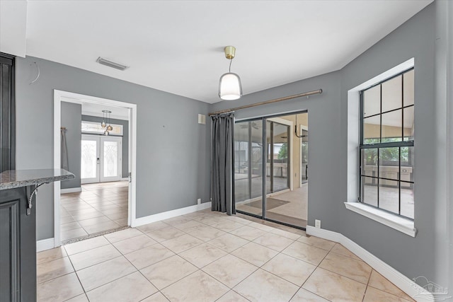 unfurnished room featuring french doors and light tile patterned floors