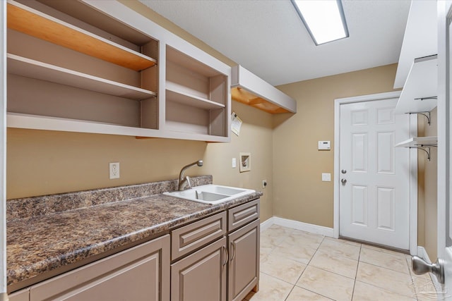 laundry room with light tile patterned flooring, washer hookup, electric dryer hookup, and sink