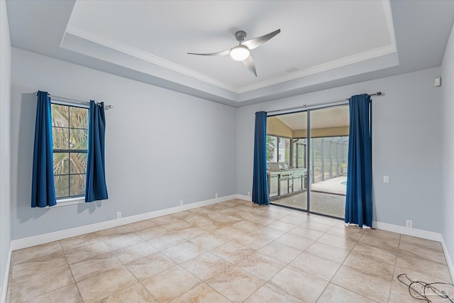 spare room with ceiling fan, light tile patterned flooring, crown molding, and a tray ceiling