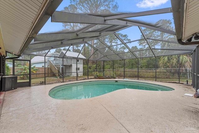 view of swimming pool featuring a patio area and glass enclosure