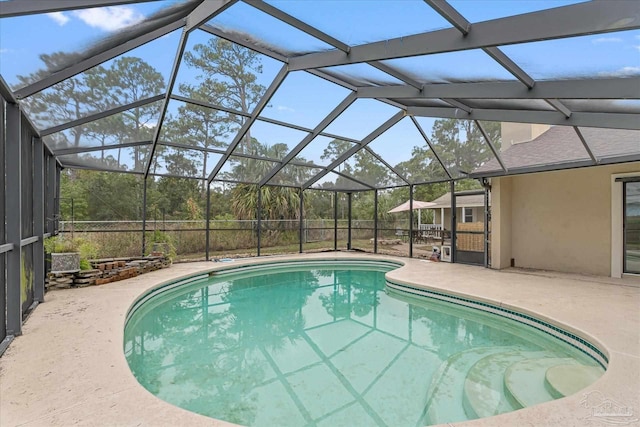 view of swimming pool featuring a lanai and a patio area