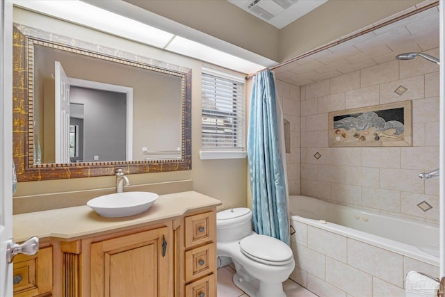 full bathroom featuring tile patterned flooring, shower / bath combo with shower curtain, vanity, and toilet