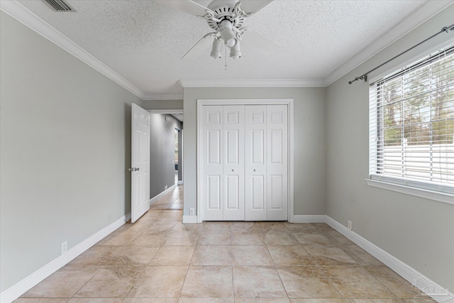 unfurnished bedroom featuring a textured ceiling, ceiling fan, crown molding, and a closet