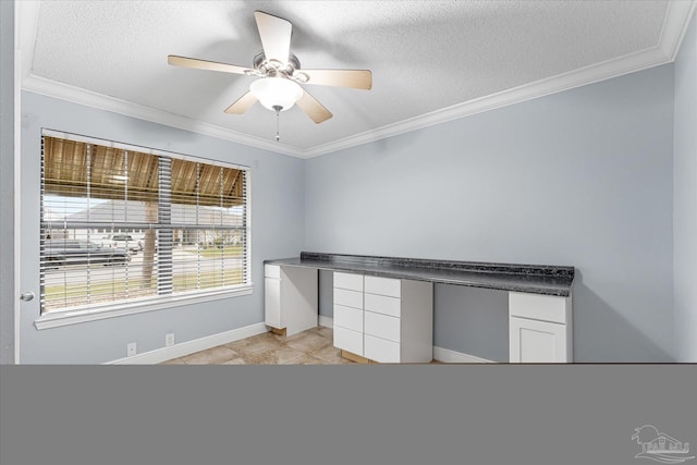 unfurnished office featuring ceiling fan, crown molding, built in desk, and a textured ceiling