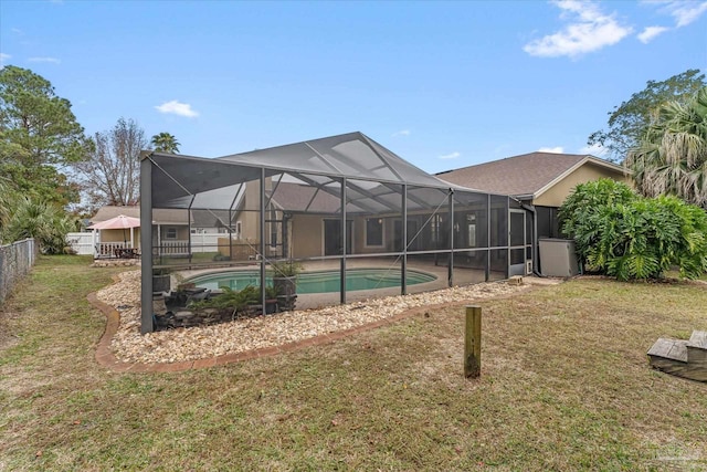 view of pool with a yard and glass enclosure