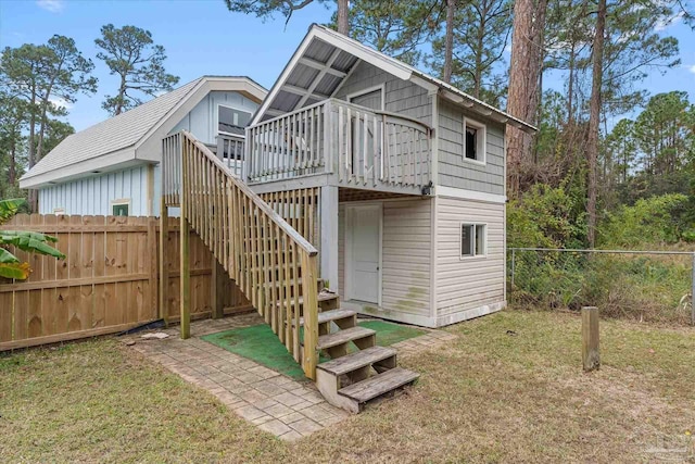 rear view of house with a lawn and a deck