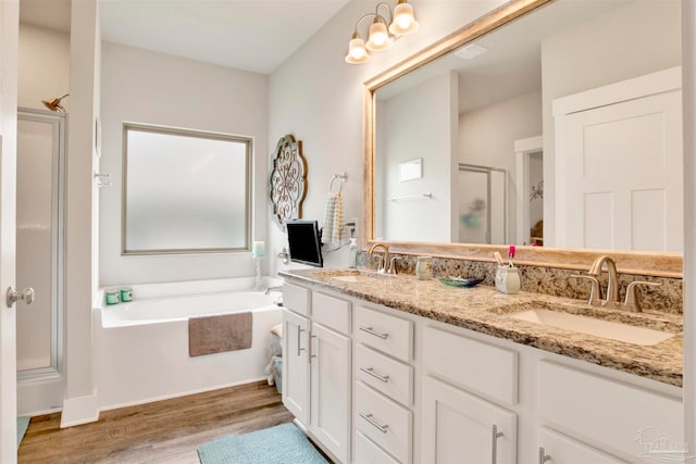 bathroom featuring vanity, hardwood / wood-style floors, and plus walk in shower