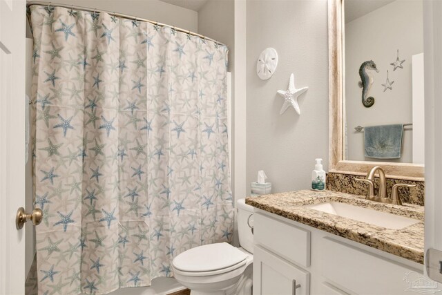 bathroom featuring vanity, toilet, and walk in shower