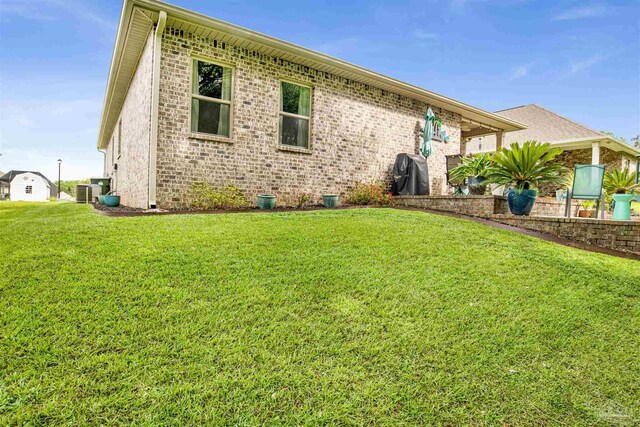 rear view of house with a yard and central air condition unit