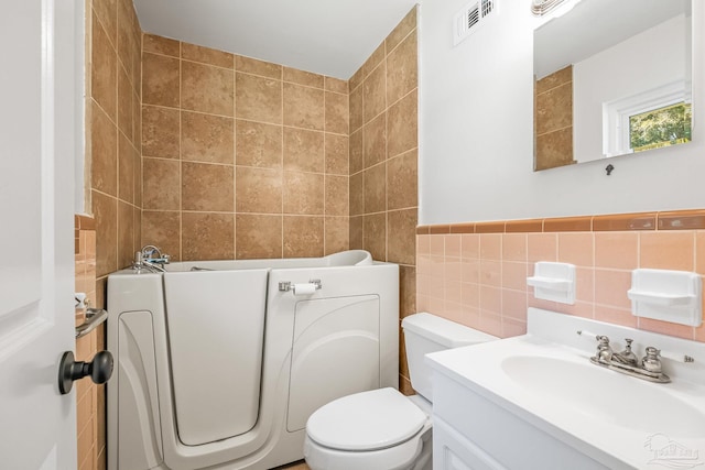 7332 Maxam Ave, Pensacola, FL 32503 - bathroom with a washtub, vanity, tile walls, and toilet