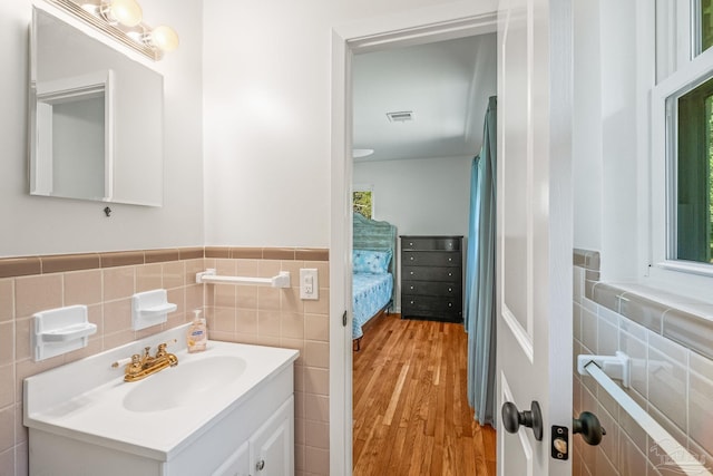 7332 Maxam Ave, Pensacola, FL 32503 - bathroom with vanity, a healthy amount of sunlight, wood-type flooring, and tile walls