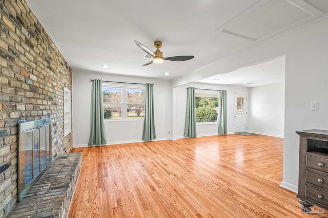 7332 Maxam Ave, Pensacola, FL 32503 - unfurnished living room featuring a brick fireplace, light hardwood / wood-style flooring, a wealth of natural light, and ceiling fan