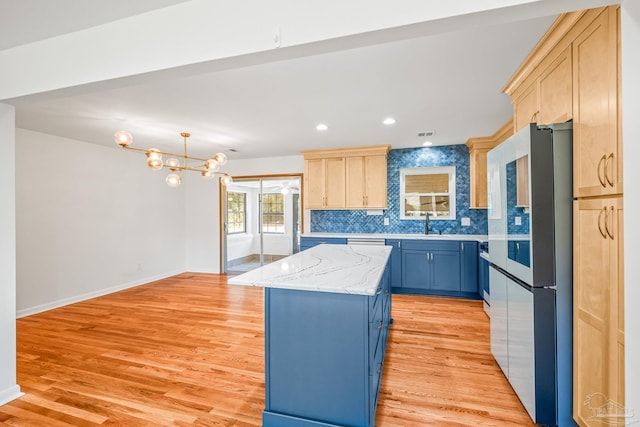 7332 Maxam Ave, Pensacola, FL 32503 - kitchen with light brown cabinetry, high end refrigerator, an inviting chandelier, light hardwood / wood-style flooring, and a kitchen island