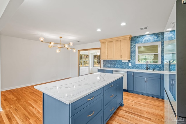 7332 Maxam Ave, Pensacola, FL 32503 - kitchen with sink, blue cabinetry, dishwasher, a center island, and light hardwood / wood-style floors
