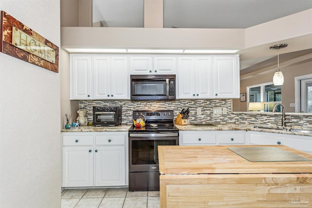 kitchen featuring sink, backsplash, pendant lighting, white cabinets, and appliances with stainless steel finishes