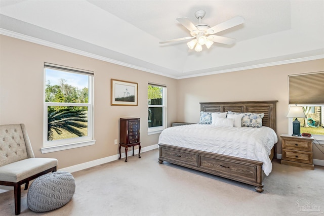 bedroom with a tray ceiling, ceiling fan, crown molding, and light colored carpet