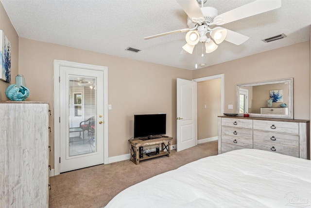 carpeted bedroom with ceiling fan and a textured ceiling