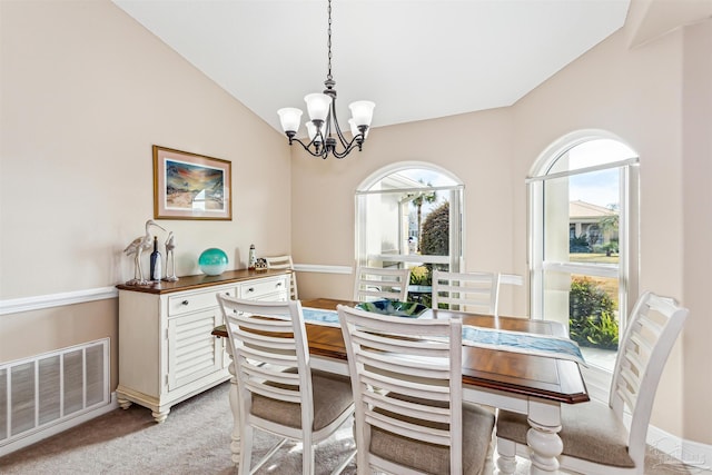 carpeted dining room with a notable chandelier and lofted ceiling