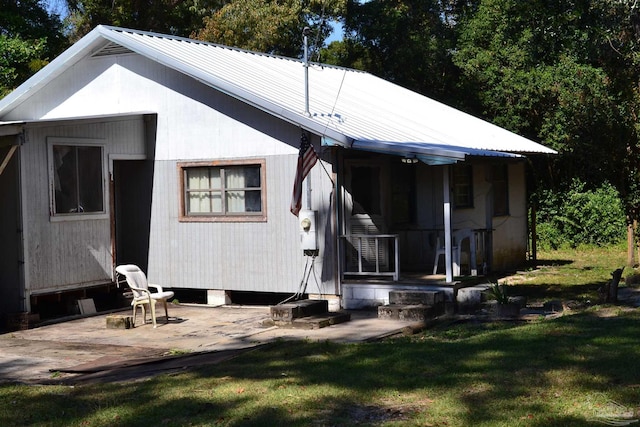 back of property with a yard and a patio area