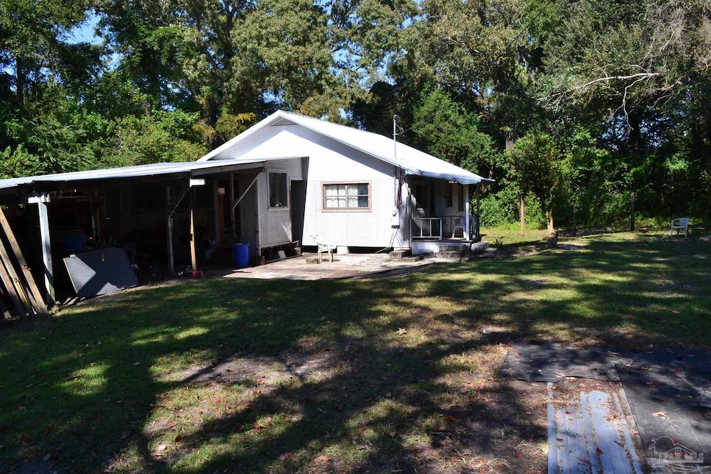 back of house with a yard and a carport