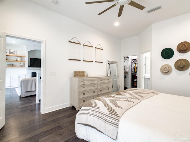 bedroom with dark hardwood / wood-style floors, a spacious closet, ceiling fan, and a closet